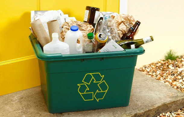 zielony kosz z przedmiotami do recyklingu